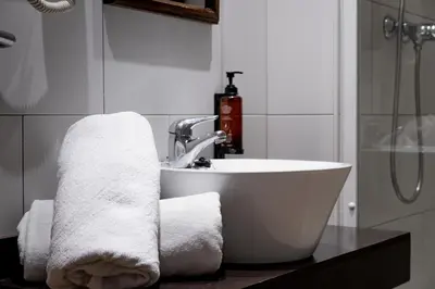 a bathroom with a sink and towels on a counter at Espanya - 30º hotels in Calella