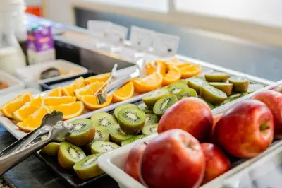 a tray of fruit with apples and oranges and a pair of scissors at Espanya - 30º hotels in Calella