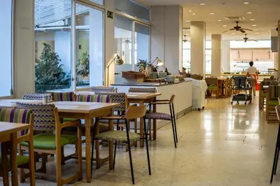 a restaurant with tables and chairs in a cafeteria at Espanya - 30º hotels in Calella