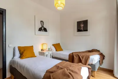 a bedroom with two beds and a table with a lamp at Canela Homes COSTA CA NOSTRA in Gavà