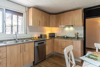 a kitchen with wooden cabinets and a sink at Canela Homes COSTA CA NOSTRA in Gavà