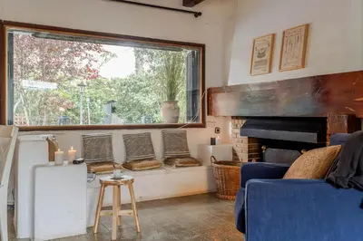 a living room with a fireplace and a window at Canela Homes COSTA CA NOSTRA in Gavà