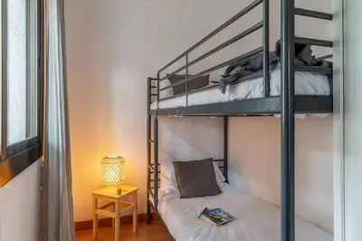 a bedroom with two bunk beds and a lamp at Canela Homes COSTA CA NOSTRA in Gavà