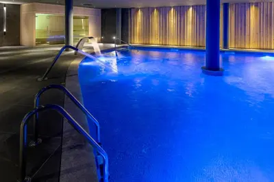 a large pool with blue water in a building at Gran Hotel Rey Don Jaime in Castelldefels
