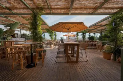 a patio with tables and chairs and an umbrella at Hotel Pulitzer Barcelona in Barcelona