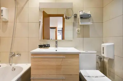 a bathroom with a sink and a toilet and a mirror at Hotel Acta Azul Barcelona in Barcelona
