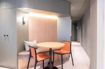 a table and chairs in a room with a hallway at Aparthotel Atenea Calabria in Barcelona