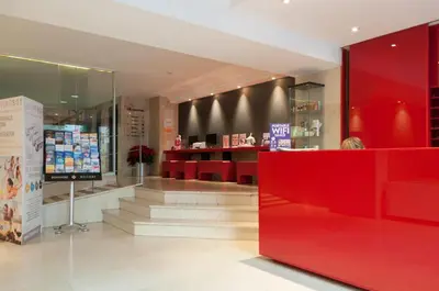 a store with a red counter and stairs in a room at Aparthotel Atenea Calabria in Barcelona