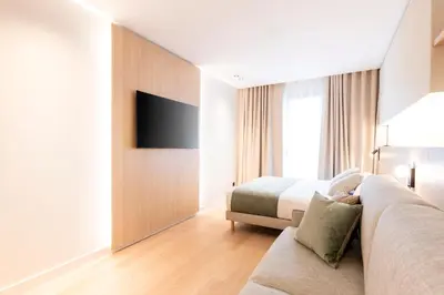 a hotel room with a couch and a bed at Aparthotel Atenea Calabria in Barcelona