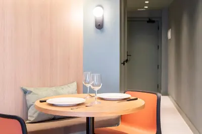 a wooden table with two glasses of wine at Aparthotel Atenea Calabria in Barcelona
