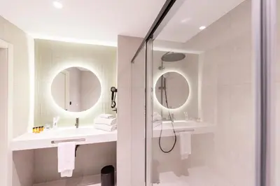 a bathroom with two sinks and two mirrors at Aparthotel Atenea Calabria in Barcelona