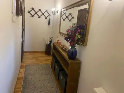 a hallway with a mirror and a vase with flowers in it at La Pastora Lux cerca de Barcelona in Gavà