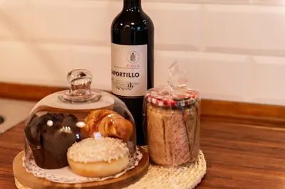 a table with a bottle of wine and a plate of donuts at La Pastora Lux cerca de Barcelona in Gavà