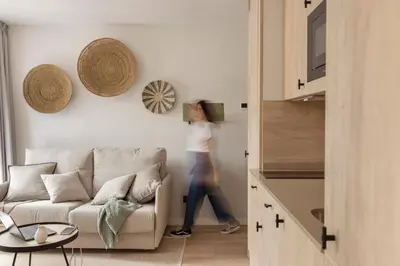a woman walking in a living room with a couch at Líbere Barcelona Sant Antoni in Barcelona