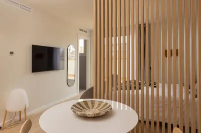 a living room with a white table and a tv at Líbere Barcelona Sant Antoni in Barcelona