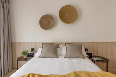 a bedroom with a large white bed with two tables at Líbere Barcelona Sant Antoni in Barcelona
