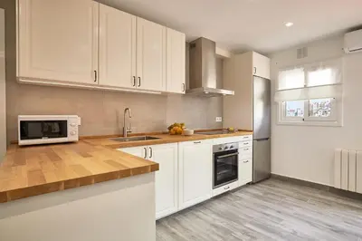 a kitchen with white cabinets and a sink and a microwave at BBarcelona El Carmel Apartment with terrace in Barcelona