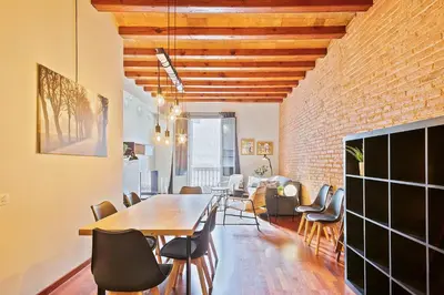 a dining room with a table and chairs and a brick wall at My Space Barcelona - Newly renovated apartment in Gràcia for families and executives in Barcelona