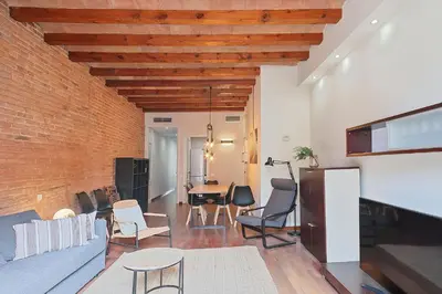 a living room with a table and chairs and a brick wall at My Space Barcelona - Newly renovated apartment in Gràcia for families and executives in Barcelona