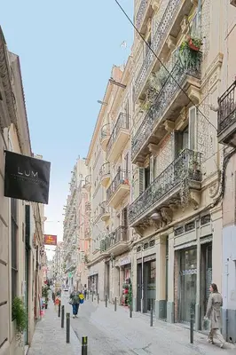 a woman walking down a city street with buildings at My Space Barcelona - Newly renovated apartment in Gràcia for families and executives in Barcelona