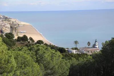 a view of a beach with a lighthouse and a house at htop Olympic #htopEnjoy in Calella