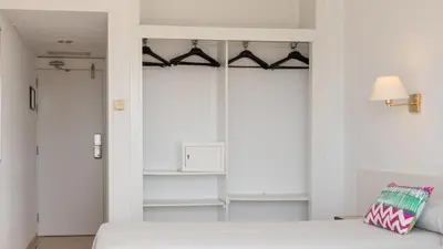 a bedroom with a bed and a closet at htop Olympic #htopEnjoy in Calella