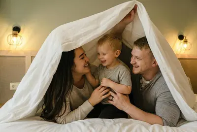 a family laying in bed under a blanket at htop Jadhe 4Sup #htopBliss in Calella