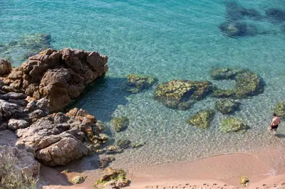 a person standing on a beach near the water at htop Amaika & SPA 4Sup - Adults Only #htopBliss in Calella