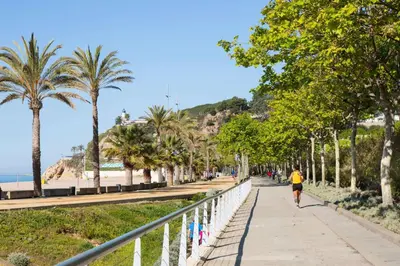 a person running down a sidewalk next to the beach at htop Amaika & SPA 4Sup - Adults Only #htopBliss in Calella