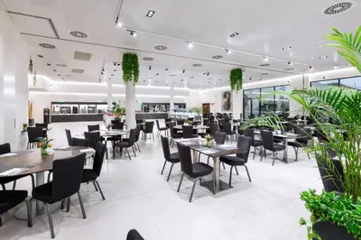 a restaurant with tables and chairs and plants at Alexandre Fira Congress in Hospitalet de Llobregat