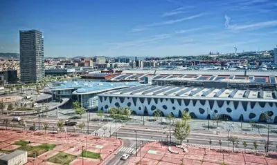 a large white building with a city in the background at Alexandre Fira Congress in Hospitalet de Llobregat