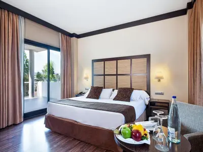 a hotel room with a bed and a table with a bowl of fruit at Aparthotel Attica 21 Vallés in Sabadell