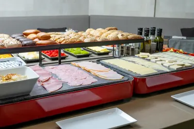 a buffet with different types of food on display at Hotel America Barcelona in Barcelona