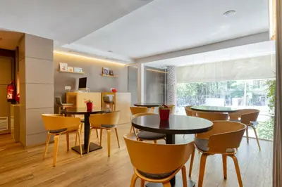 a dining room with tables and chairs and a large window at Hotel America Barcelona in Barcelona