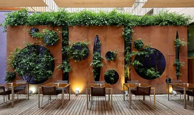 a restaurant with tables and plants on a wall at Hotel Barcelona Catedral 4 Sup in Barcelona