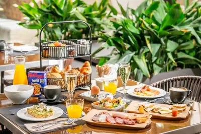 a table with plates of food and glasses of orange juice at Hotel Barcelona Catedral 4 Sup in Barcelona