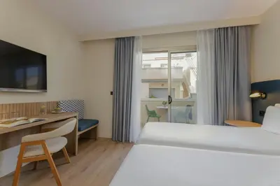 a hotel room with a bed and a desk at Sercotel Kalma Sitges in Sitges