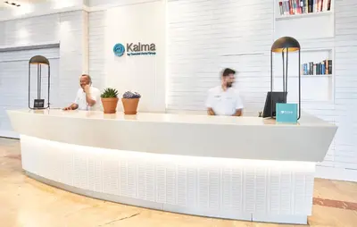 two people sitting at a counter in a lobby at Sercotel Kalma Sitges in Sitges