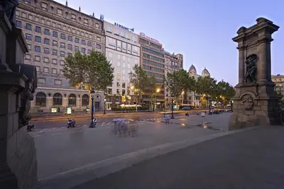 a city street with a large building and a clock tower at Olivia Plaza Hotel in Barcelona