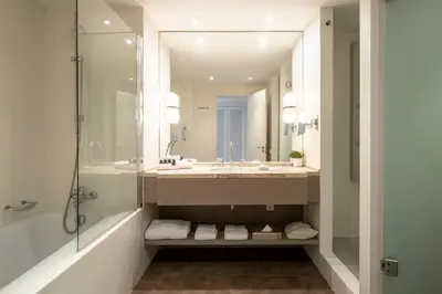 a bathroom with a tub and a sink and a mirror at Eurostars Sitges in Sitges