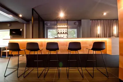 a bar with black stools in a room at Aparthotel Atenea Valles in Granollers
