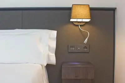 a bedroom with a bed and a lamp on a wall at Aparthotel Atenea Valles in Granollers