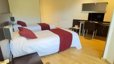 a hotel room with two beds and a flat screen tv at Hotel Bruc in El Bruc