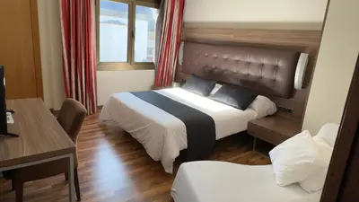 a hotel room with a bed and a desk at Hotel Bruc in El Bruc