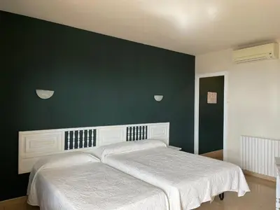 a bedroom with a bed with a green wall at Hotel Bruc in El Bruc