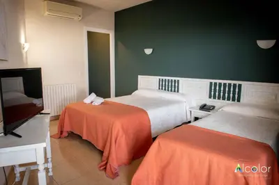 a bedroom with two beds and a flat screen tv at Hotel Bruc in El Bruc