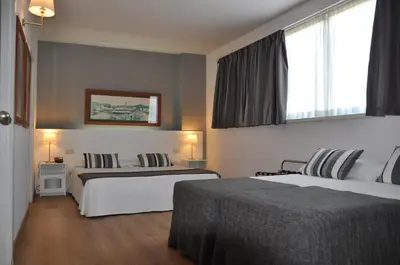 a hotel room with two beds and a window at Aparthotel Atenea Barcelona in Barcelona