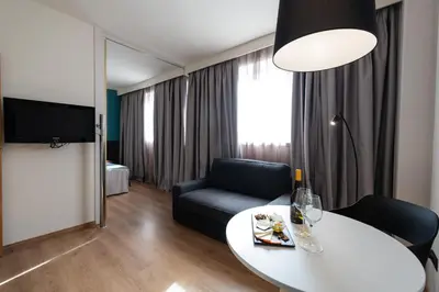 a living room with a white table and a chair at Aparthotel Atenea Barcelona in Barcelona