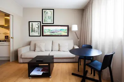 a living room with a couch and a table at Aparthotel Atenea Barcelona in Barcelona