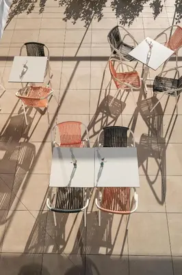 a group of tables and chairs on a patio at Apartamentos Marfina in Castelldefels